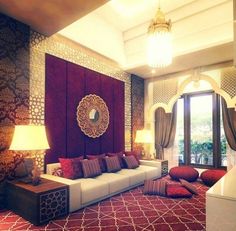 a living room filled with lots of furniture and pillows on top of a red rug