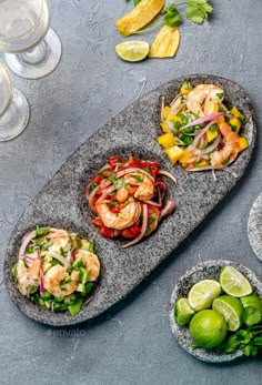 shrimp salads with lime and cilantro served on stone platters next to wine glasses