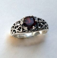 "You're beautiful A great design exposes sterling silver filigree ring with a deep red garnet stone set with prongs. (code- R2115) © 2011-2015, Artisanimpact Inc. All rights reserved. Construction and dimensions: Sterling silver, garnet Approximate diameter on top 7mm (0.27\") We can make any size, including quarter sizes. Please just indicate the requested size in the order. About our jewelry Artisanlook offers an exciting collection, designed and made by artisanimpact inc, especially for occas Wedding Silver Garnet Birthstone Ring, Silver Garnet Solitaire Ring, Ornate Round Ruby Ring, Elegant Sterling Silver Ruby Ring With Birthstone, Ornate Round Garnet Rings, Ornate Garnet Round Rings, Wedding Rings With Intricate Garnet Design, Elegant Handmade Silver Birthstone Ring, Ruby Ring With Intricate Design For Wedding