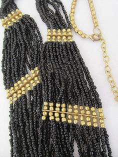 "Bib necklace seed bead necklace black seed bead flapper necklace vintage bead necklace Gatsby style Art Deco vintage 90s. This is an awesomely spectacular necklace hung with a mass of black glass seed beads and beautiful antique look gold tone beads. This high quality piece of jewelry which has a totally cool retro 1920s feel is in very good condition. A real attention grabber and extremely flattering; a real winner at your next Gatsby party.  Make sure to check out all the photos. Length of th Gift Black Bib Necklace With Colorful Beads, Black Bib Necklace With Colorful Beads For Gift, Black Vintage Jewelry With Multicolored Beads, Vintage Black Jewelry With Colorful Beads, Black And Gold Beads For Festival, Black Beads With Gold Details For Festival, Black Tiny Beads Necklace For Party, Bohemian Black Bib Necklace With Colorful Beads, Black Bohemian Bib Necklace With Colorful Beads