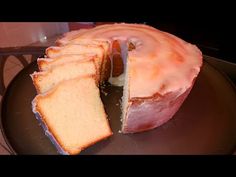 a bundt cake with pink icing and slices cut out on a black plate