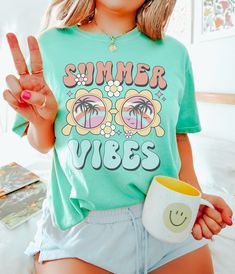 "Get ready to enter vacay mode and enjoy the sunshine with our cute Summer Vibes tee. This Comfort Colors t-shirt is perfect for the beach and is available in 6 beautiful colors for you to choose from. It has a relaxed fit and, if you order 2 sizes up from your normal size, you get that trendy oversized look.  KEY FEATURES: *Super comfy 100% ring-spun cotton, without side seams *Medium fabric (6.1 oz/yd² (206.8 g/m *Relaxed fit *Garment-dyed fabric gives a soft feel and colors, for that retro look *Double stitching which makes your cute tee last longer CARE INSTRUCTIONS: *Machine wash: cold (max 30C or 90F) *Do not bleach *Tumble dry: low heat *Iron, steam or dry: low heat *Do not dryclean COLOR DISCLAIMER:  Please note that colors shown in our product images may vary slightly and differ f New Mom Outfits, Surfer Shirt, Watermelon Shirt, Summer Tees, Beach Lover Gifts, Vacay Mode, Summer Graphic Tee, Tan Woman, Beach Lover