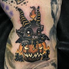 a close up of a person's leg with tattoos on it and an orange pumpkin