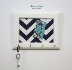 there is a key hanging on the wall next to a frame with a blue and white pattern