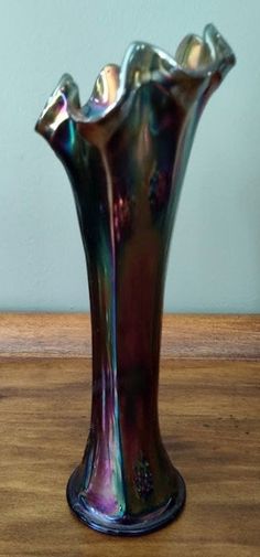 a silver vase sitting on top of a wooden table