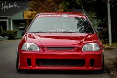 a red car is parked on the street