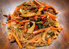 stir fried noodles with vegetables in a silver bowl