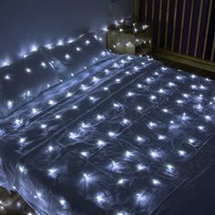 an unmade bed covered in white lights