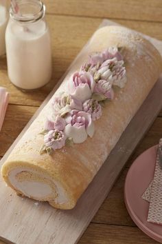 a long loaf of bread with flowers on it sitting on top of a wooden table