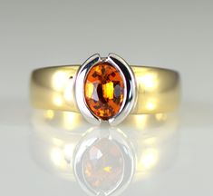 A brilliant orange gem Spessartite Garnet is semi bezel set in 14k white gold with a wide yellow gold shank. Spessartite, a rare form of garnet, also called mandarin or Malaya garnet, ranges from a yellow-orange through brilliant orange to orange-red. They combine very good hardness with excellent brilliance and sparkle. Spessartite is found in Africa and like all garnets is untreated. Garnet is January's birthstone and the 2nd wedding anniversary gemstone. The spessartite garnet is an 8 x 6 mm Laos Jewelry, Malaya Garnet, 2nd Wedding, 2nd Wedding Anniversary, Orange Gem, Spessartite Garnet, Solid Gold Ring, Etsy Gold Ring, White Solid