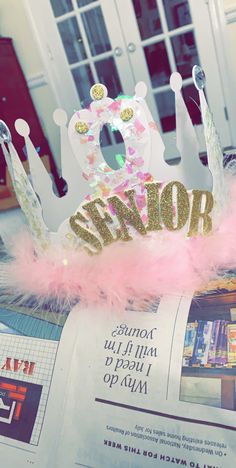 a pink and gold crown sitting on top of a magazine