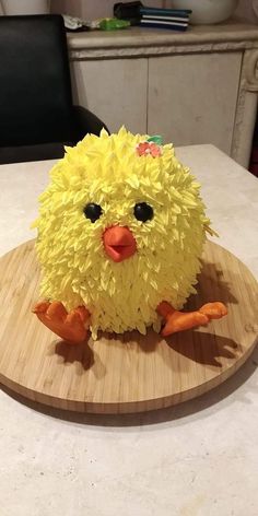 a cake made to look like a chicken sitting on top of a cutting board with paper machs all over it