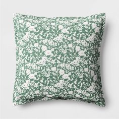 a green pillow with white flowers on it