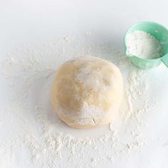 a ball of dough next to a measuring cup