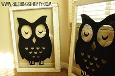 two black and white owls sitting on top of a window sill next to each other