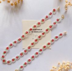 the beaded bracelets are decorated with red and green beads, along with a greeting card