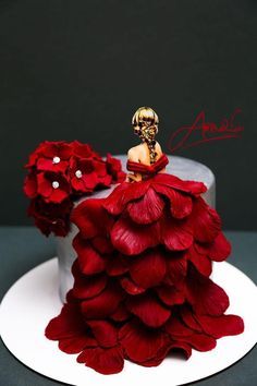 a cake decorated with red flowers and a skeleton figurine sitting on top of it