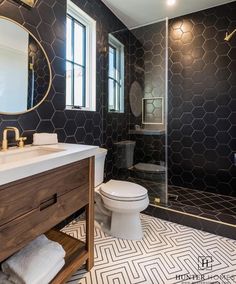 a bathroom with black and white tiles on the walls