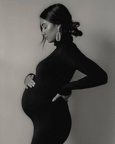 a pregnant woman poses for a black and white photo in a tight, long - sleeved dress