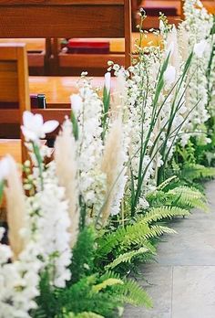 white flowers line the side of pews in a church