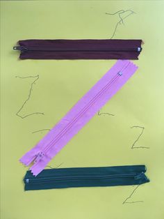 three different zippers are shown on a yellow paper background, one is purple and the other is teal