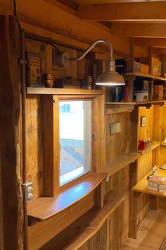 the inside of a cabin with wooden walls and shelves