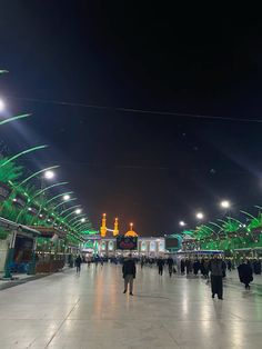 people are walking around in the middle of an indoor market area at night with green lights