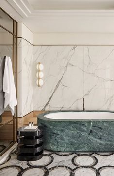 an elegant bathroom with marble walls and flooring, along with a large bathtub