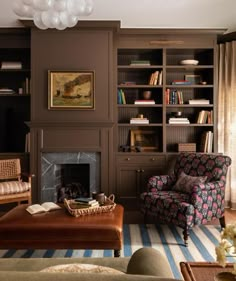 a living room filled with furniture and a fire place next to a book shelf full of books