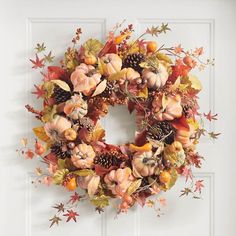 a wreath with autumn leaves and pumpkins