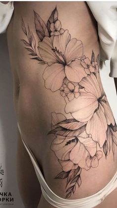 a woman's back with flowers on it and the bottom half of her stomach