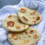 three pita breads sitting on top of a white cloth