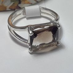 This Simple Sideways Set Ring Features A 10x8mm Emerald Cut Smokey Topaz, Set With 4 Sterling Prongs. The Mounting Is A Split Shank, And Measures Aprox 3/8" In Width & Weighs Aprox 3.439 Grams Of Solid (Stamped 925 Inside The Shank) Sterling Silver. This Simple Sideways Set Smokey Topaz Ring Has A Msrp Of $399.00. Finger Size 6 Formal Octagon Topaz Ring In Sterling Silver, Formal Sterling Silver Topaz Ring With Rectangular Stone, Sterling Silver Topaz Ring With Rectangular Stone For Formal, Hallmarked Silver Emerald-cut Gemstones, Octagon Silver Topaz Ring In Sterling Silver, Silver Octagon Topaz Promise Ring, Silver Octagon Topaz Ring In Fine Jewelry Style, Modern Silver Topaz Ring With Emerald Cut, Silver Octagon Topaz Ring Fine Jewelry