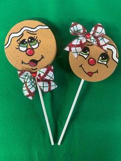 two decorated lollipops sitting on top of a green cloth covered table next to each other