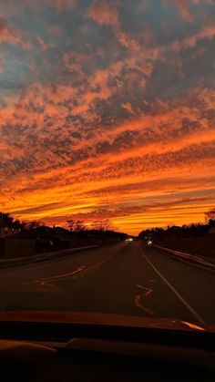 an orange and blue sky is seen from the inside of a car