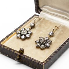 The Natalie earrings are inspired by the Victorian style. They center 2 old mine cut diamonds of K color and SI1 clarity that weigh 1.10ctw. The center stones are surrounded by 16 old mine cut diamonds of J/K color and VS2-SI1 clarity that weigh 2.70ctw. Earring measurement: 22mm by 14mm by 4mm Total weight: 5.0 grams / 3.2 dwt Victorian Diamond White Earrings With Diamond Accents, Antique Rose Cut Diamond White Earrings, Antique Rose Cut Diamond Earrings In Diamond White, Antique Single Cut Diamond White Earrings, Victorian Style Diamond White Rose Cut Diamond Earrings, Victorian Rose Cut Diamond Earrings In Diamond White, Antique Diamond White Earrings With Single Cut Diamonds, Victorian Rose Cut Diamond White Earrings, Victorian Diamond Earrings With Diamond Accents