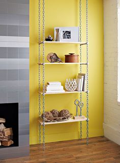 a room with yellow walls and shelving next to a fire place in the corner