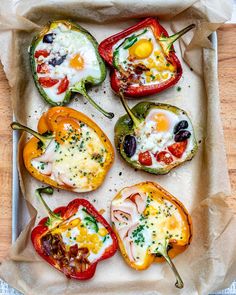 six stuffed bell peppers with eggs in them on a wooden tray, ready to be eaten