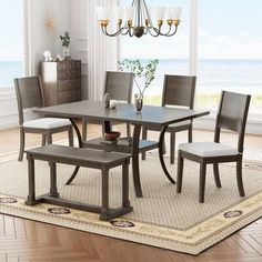 a dining room table with four chairs and a chandelier