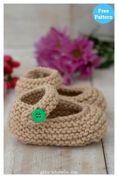 crocheted baby booties with a button on the side and flowers in the background