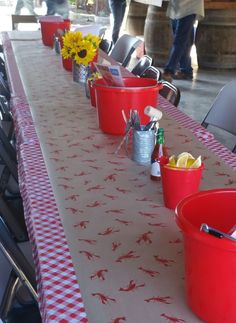 red buckets are lined up on a long table