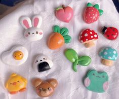 there are many different types of buttons on the table together, including an egg, mushroom, and other items