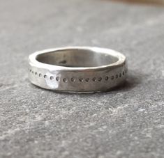 A great chunky ring with a free hand stamped ring of dots going all the way around. The silver has a hammered rough luxe texture from being beaten into shape. Comfortable to wear and strong enough for everyday. Perfect as an alternative silver wedding band if desired. Due to the making process each ring is unique so please allow for some variation as your ring will be made to order. Please send your ring size when ordering. The video shows the ring with a flush set pink sapphire, please message Thick Silver Ring, Silver Hammered Ring, Texture Jewelry, Small Silver Hoop Earrings, Minimalist Silver Ring, Chunky Silver Rings, Hand Stamped Ring, Hammered Silver Ring, Faceted Ring