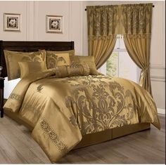 a bed with gold comforter and matching curtains