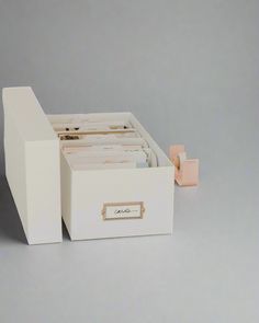 a white box containing several files and a small pink object in the bottom right corner