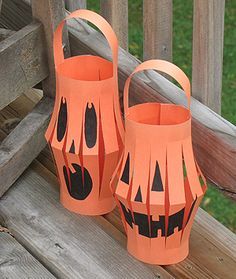 two orange paper lanterns sitting on top of a wooden deck