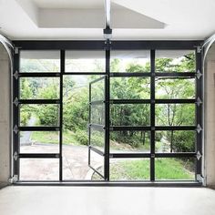 an empty room with glass doors and trees in the background