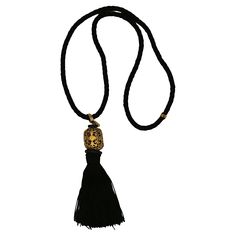 YVES SAINT LAURENT vintage black rope necklace featuring a black tassel topped by a gorgeous openwork gold tone cylinder. Probably designed by MAISON DENEZ for YVES SAINT LAURENT. Embossed YSL. Indicative measurements : wearable length (excluding the pendant) approx. 29 cm (11.42 inches) / height of the pendant (including tassel) approx. 11.5 cm (4.53 inches). Materials : Rope / Tassel / Gold tone metal / Wood / Resin. NOTES - This is a preloved vintage item, therefore it might have imperfections. - Colors may differ slightly from actual product appearance due to differences in lighting conditions. - As a buyer, you are fully responsible for customs duties, other local taxes and any administrative procedures related to imports into the country of destination. Black Rope Necklace, Saint Laurent Vintage, Tassel Top, Black Rope, Brooch Necklace, Disc Pendant, Beaded Choker Necklace, Rope Necklace, Cross Pendant Necklace