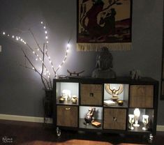 a room with some lights on the wall and a shelf full of vases in it