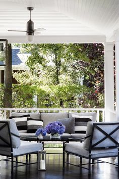 a living room with couches and chairs on the porch